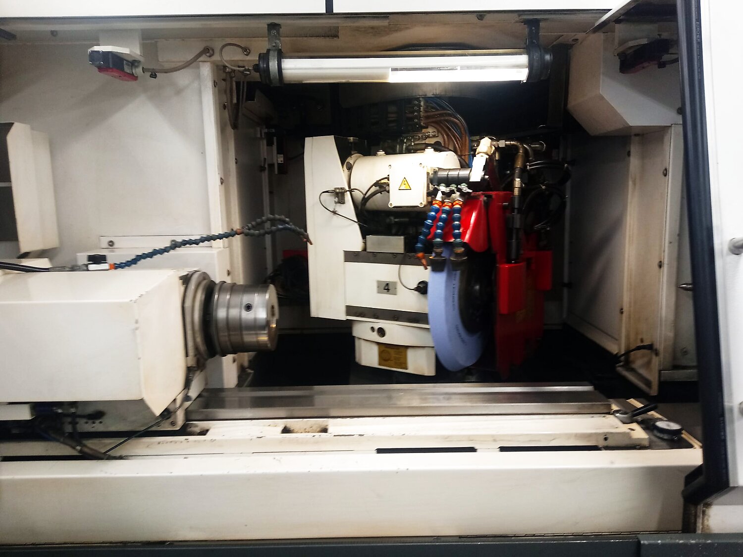 Schleifscheibe und Werkstückaufnahme im Inneren der CNC-Rundschleifmaschine
